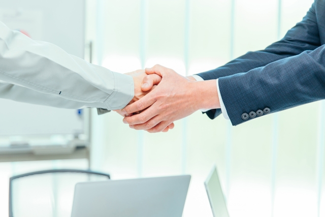 顧客と握手をするビジネスマン