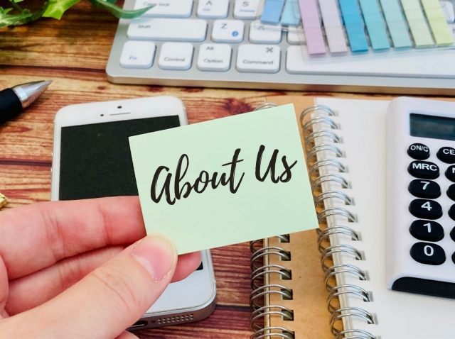 About us　の文字列とスマホとノート