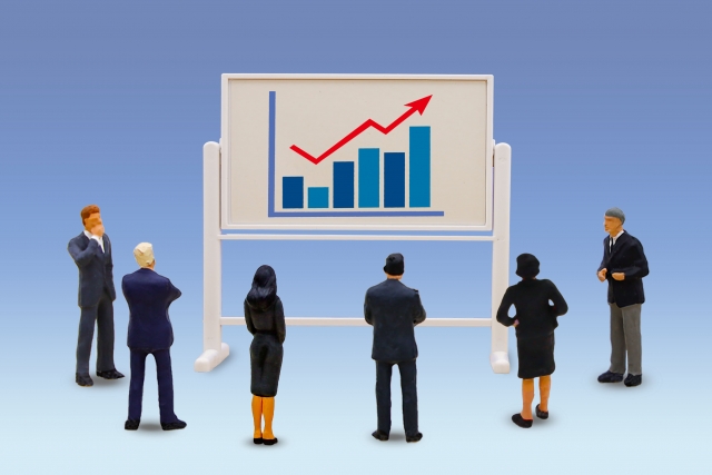 棒グラフを見つめるビジネスマンたち